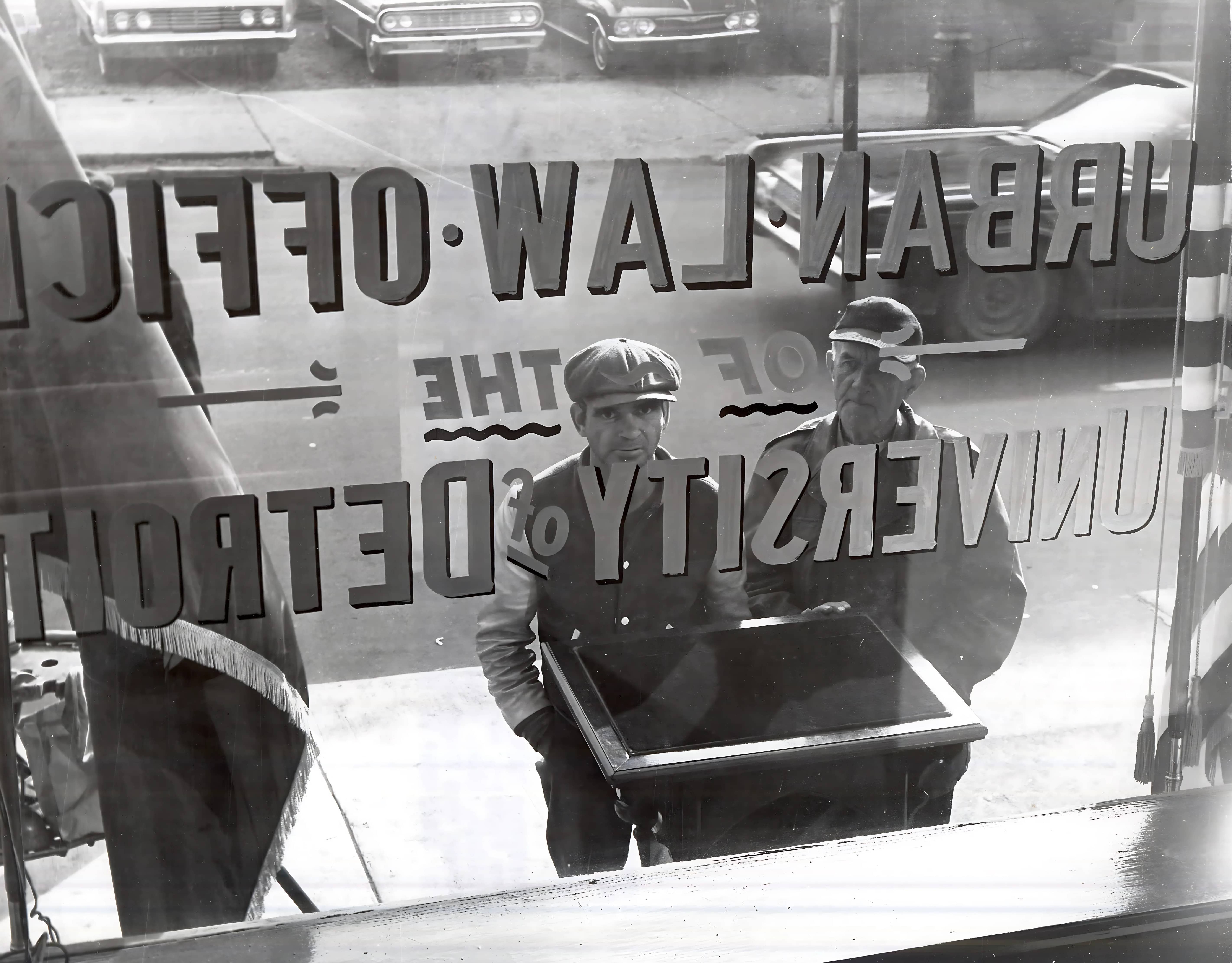 man cleaning window of urban law clinic